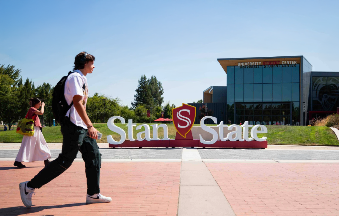 Stanislaus State Student Center building with sign that says Stan State, and students walking by.
